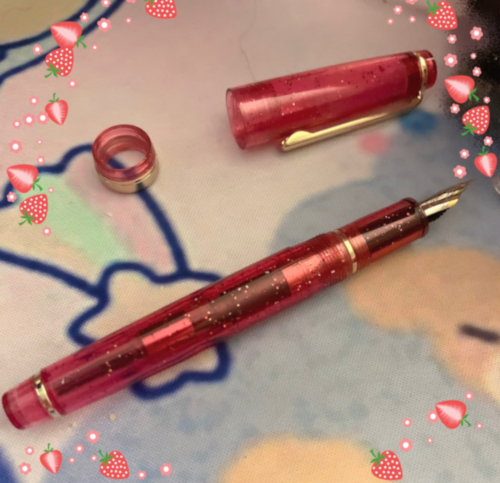 a broken sparkly rose pink jinhao 82 pen. the lid has split in half so that it can no longer be screwed on.