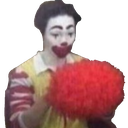 man sadly putting on clown wig & makeup